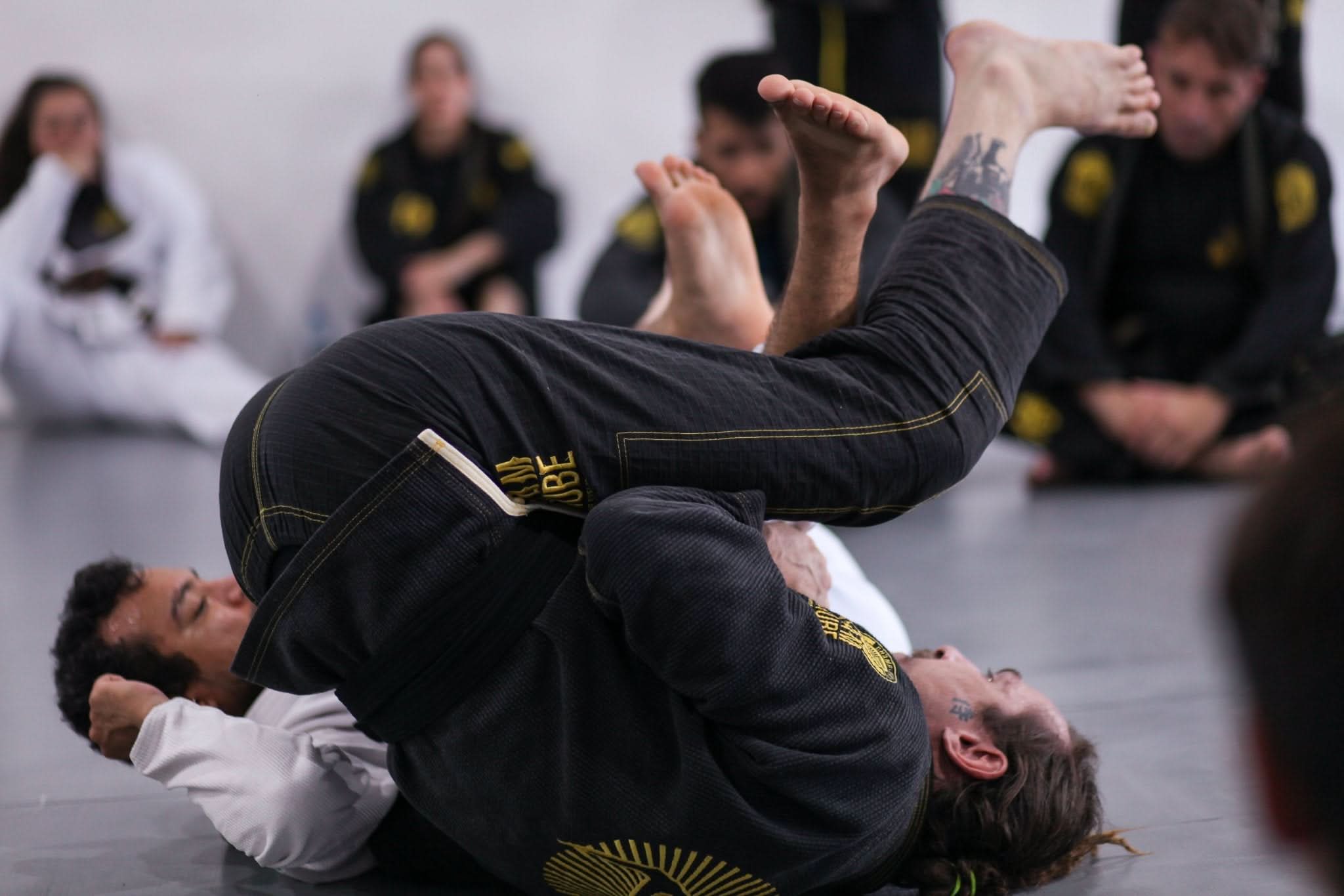Atleta de Jiu Jitsu no Tatame com um Kimono Preto personalizado pela KimonoLab
